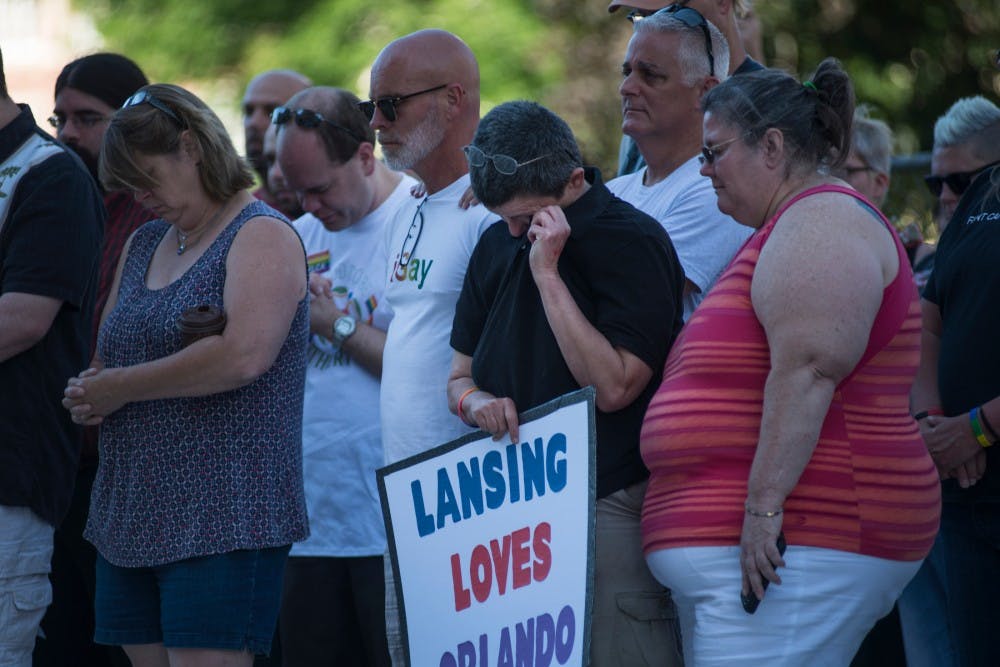 Jackson, Mich. resident Nikki Joly, center, wipes away tears during the candlelight vigil for Orlando on June 12, 2016 at the Capitol in Lansing. Lansing Association of Human Rights hosted the vigil for people that wanted to gather and mourn for Orlando's victims of violence.