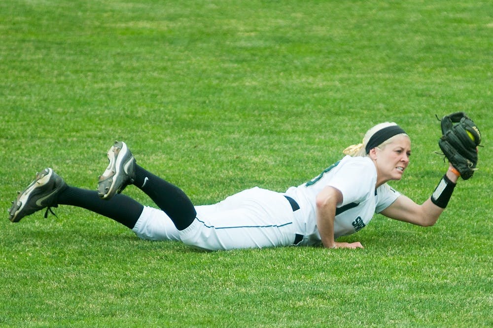 <p>Junior outfielder Alyssa McBride dives for the ball during the game against Michigan on April 13, 2014, at Secchia Stadium at Old College Field. The Spartans were shut out by the Wolverines, 14-0. Danyelle Morrow/The State News</p>