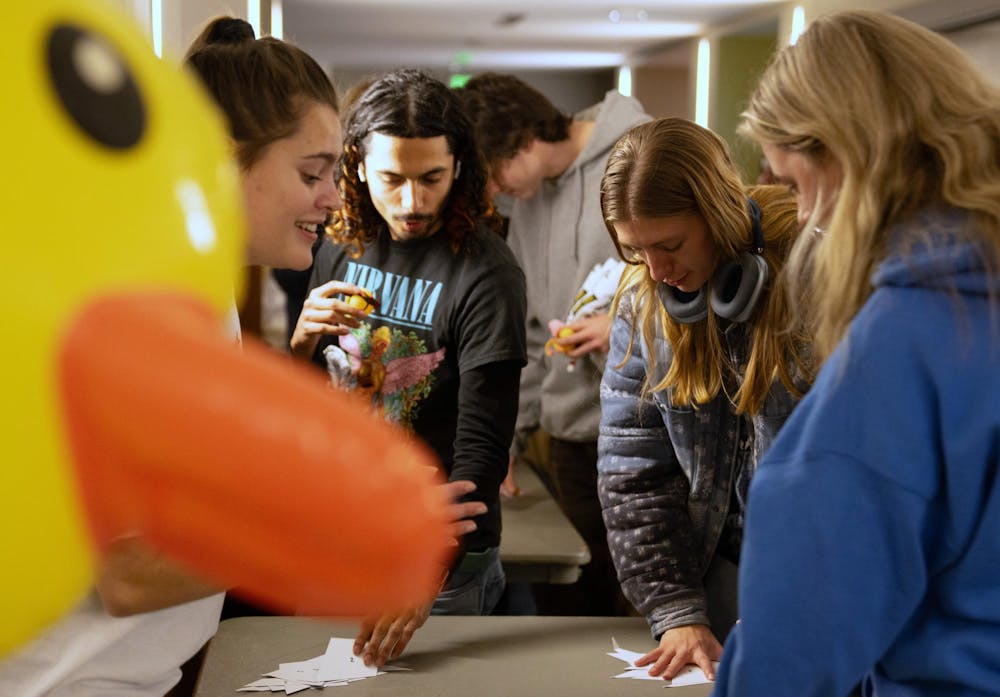 Michigan State crop and soil science senior and Alcohol and Other Drugs Program volunteer Kaili Heinze, left, helps statistics senior Freddy Villalobos and others decorate rubber ducks at the Farewell to the Flock event at the student union on Dec. 2, 2024.