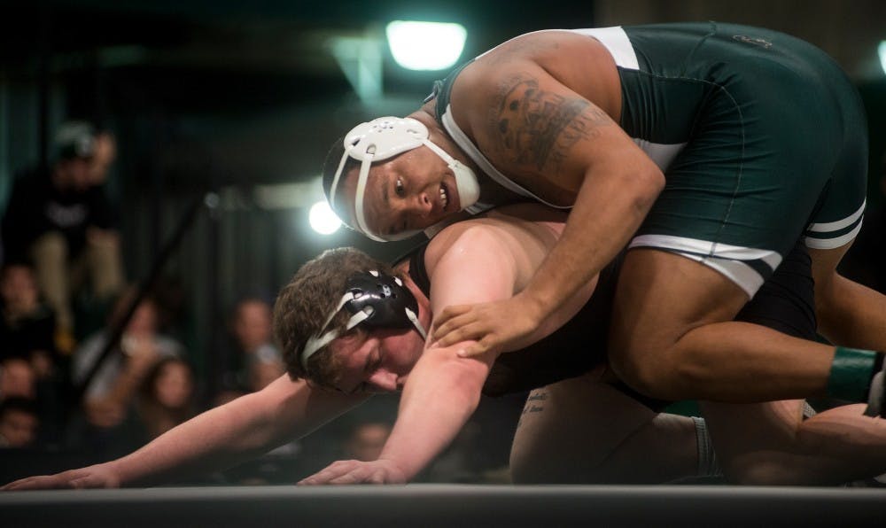 Junior heavyweight Dimitrus Renfroe pins Eastern Michigan wrestler Gage Hutchison during a meet against Eastern Michigan University on Dec. 2, 2015 at Jenison Field House. The Spartans were defeated by the Eagles, 34-0. 