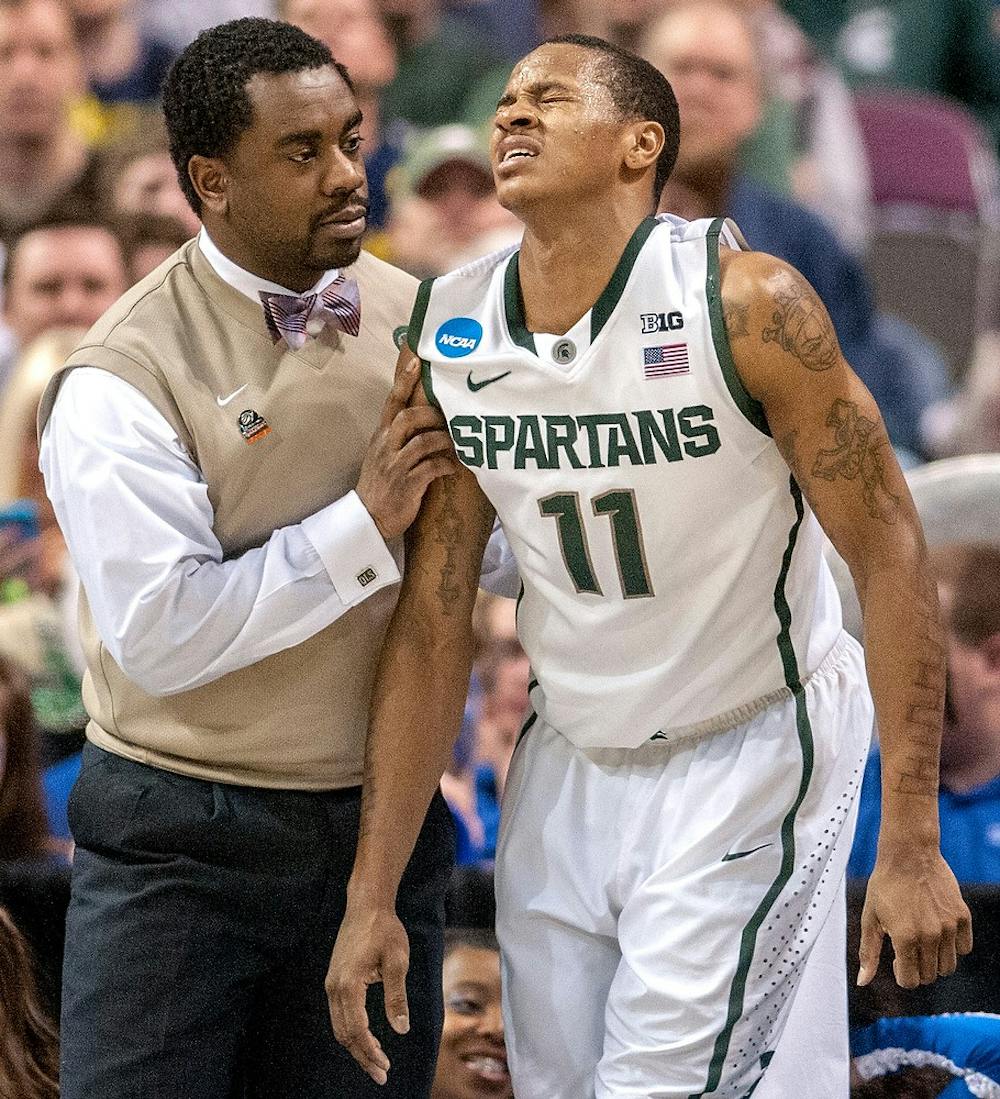 	<p>Athletic trainer Quinton Sawyer helps junior guard Keith Appling to get up from the floor after Appling injuired himself during the second half during the third round of the <span class="caps">NCAA</span> Tournament on Saturday at The Palace of Auburn Hills in Auburn Hills, Mich. Justin Wan/The State News</p>