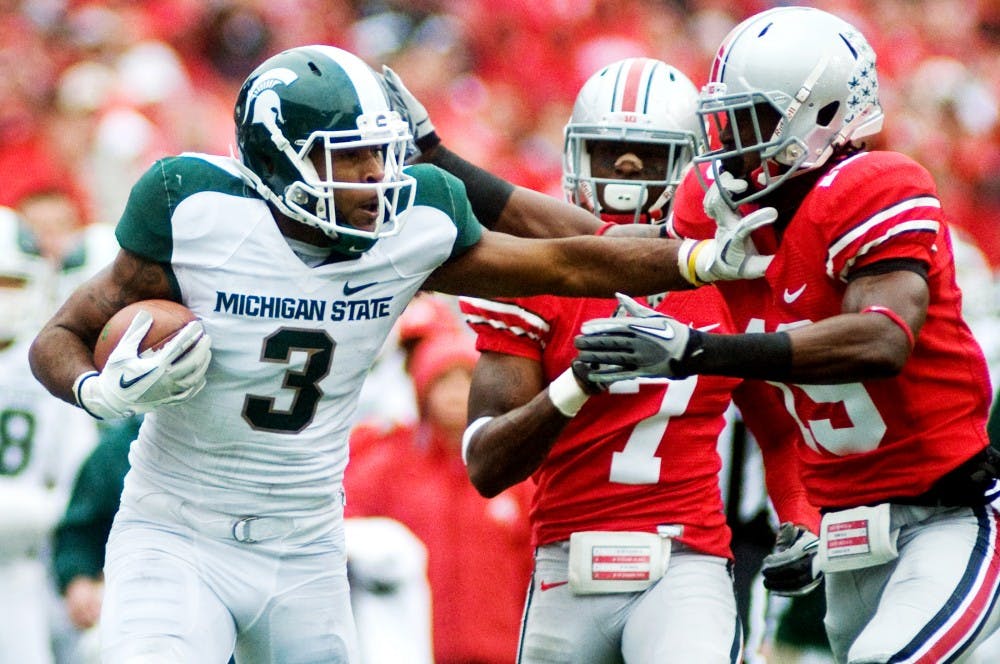 Senior wide receiver B.J. Cunningham runs the ball after completing a pass for 52 yards as Ohio State defensive back Orhian Johnson attempts to push him out of bounds during Saturday's game at Ohio Stadium in Columbus, Ohio. Lauren Wood/The State News