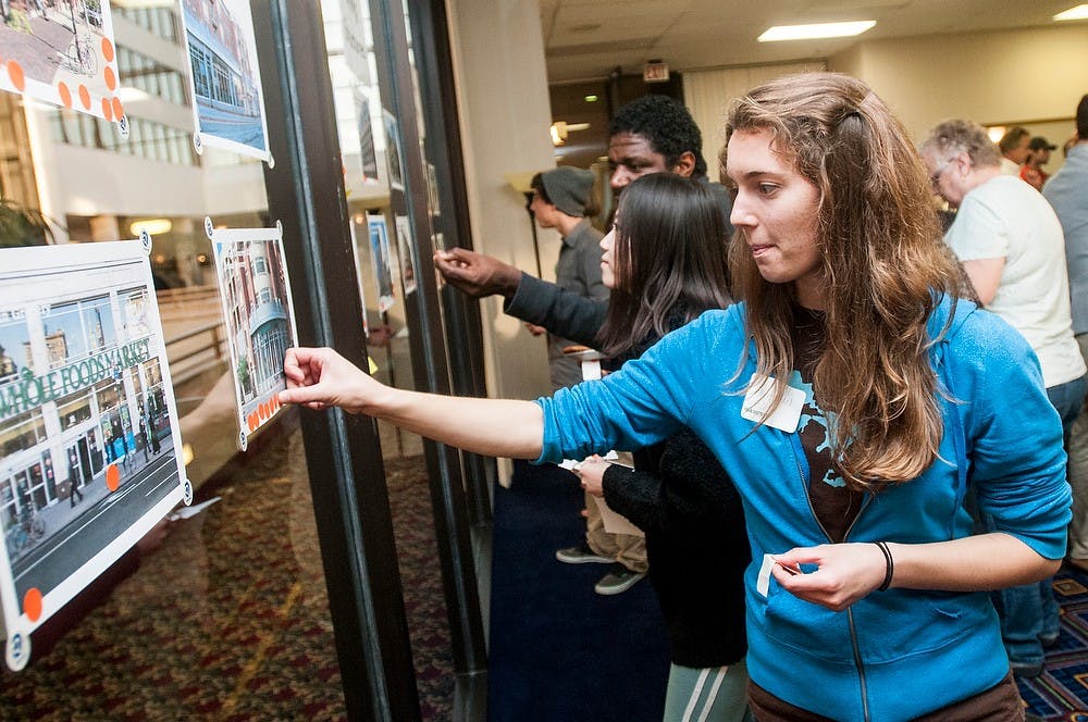 	<p>Dietetics senior Emily Hazel casts her vote for potential building designs Sept. 30, 2013, at the Marriott Hotel. The charrette allowed for residents to learn about the park district project and vote on what they would like to see built. Khoa Nguyen/The State News</p>