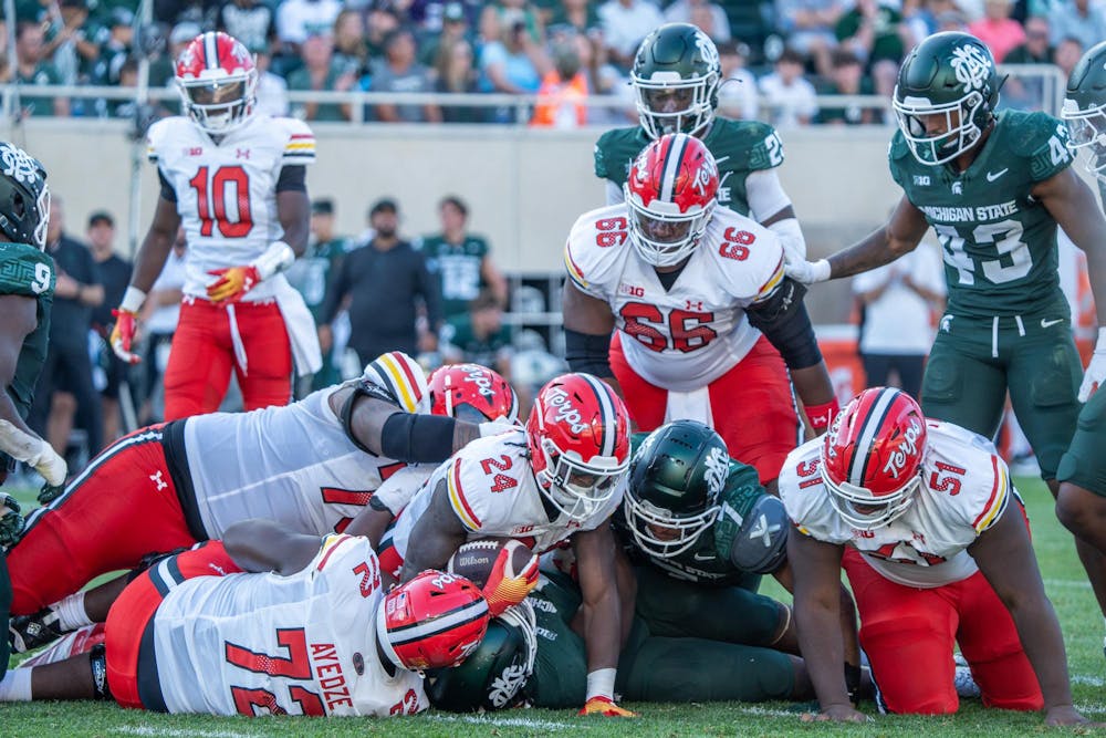 <p>Maryland players pile up on a Michigan State player during the game at Spartan Stadium on Sept. 23, 2023. The Spartans ultimately lost to the Terrapins 31-9.</p>
