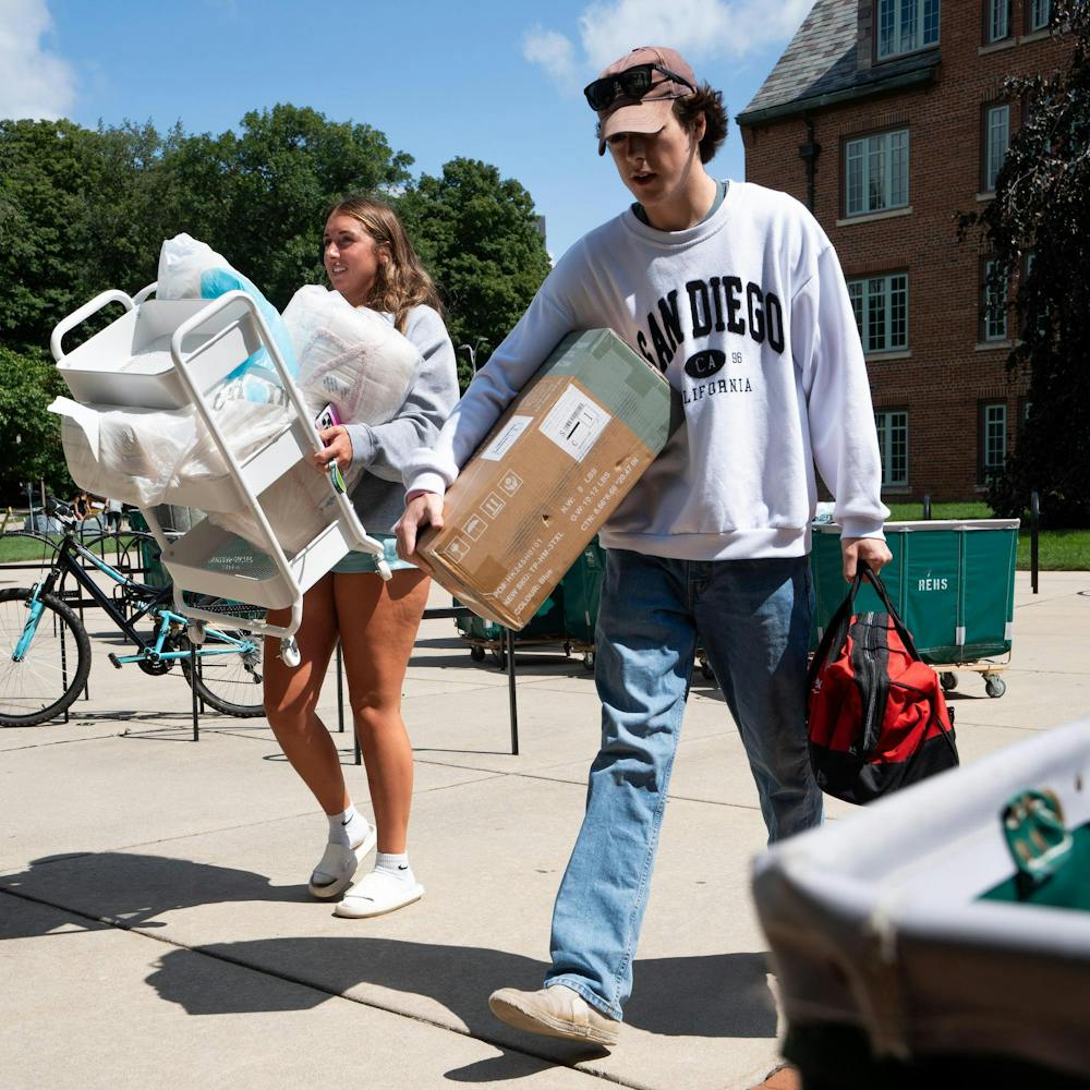 <p>Danica Badawi, left, an exploratory business preference freshman and her brother Caleb carry her belongings to her room in Yakeley Hall, Aug. 20, 2024.</p>