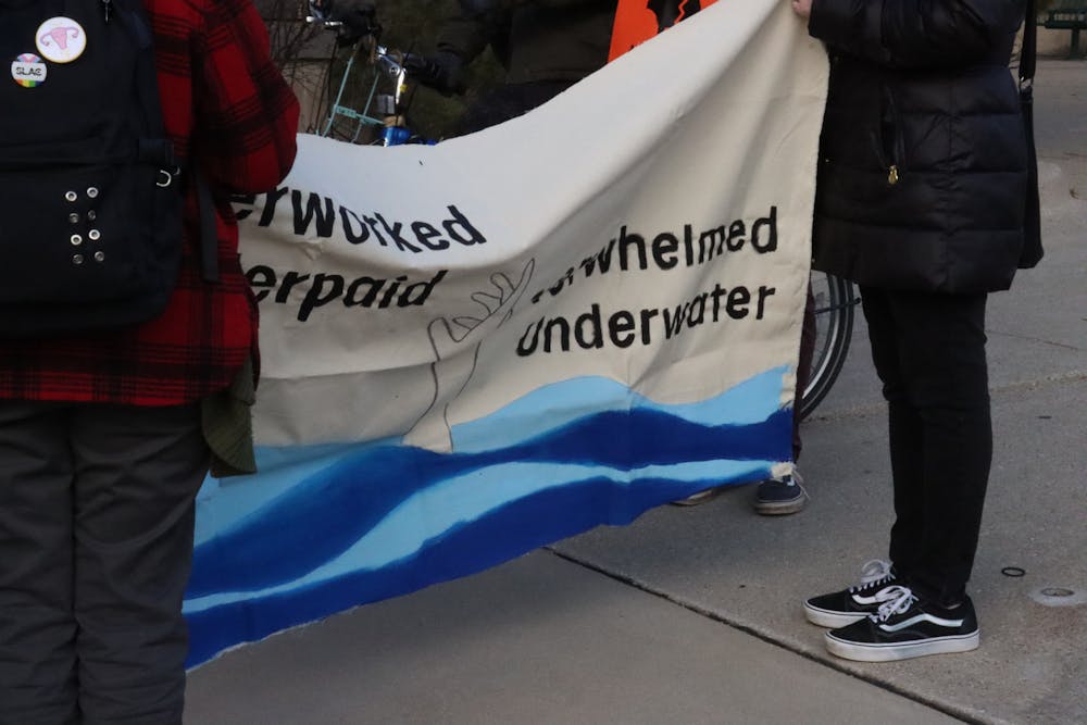 <p>An example of another banner created reads, "Overworked, underpaid, overwhelmed, underwater." Graduate students demand change and more affordable health care, on March 21, 2024.</p>