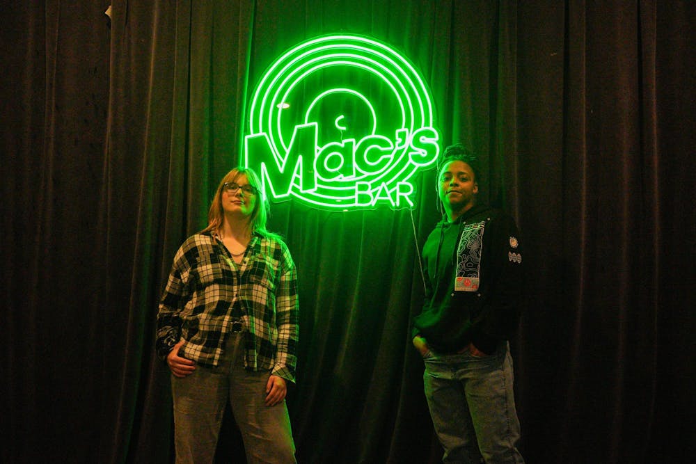 <p>Jillian Plant and Jay Thratts, two of five members of the all-queer/non-binary performance group known as Compound Kinetics, pose for a photo on stage at Mac’s Bar in Lansing on Oct. 18, 2023. They will be performing on Oct. 26 at Mac’s Bar.</p>