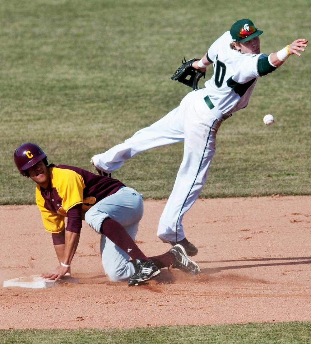 Redshirt sophomore second baseman Ryan Jones misses the ball as Central Michigan outfielder Sam Russell tags the base in the top of the seventh inning on Wednesday at McLane Stadium at Kobb Field. The Spartans lost to the Chippewas, 3-1, in the home opener. Josh Radtke/The State News