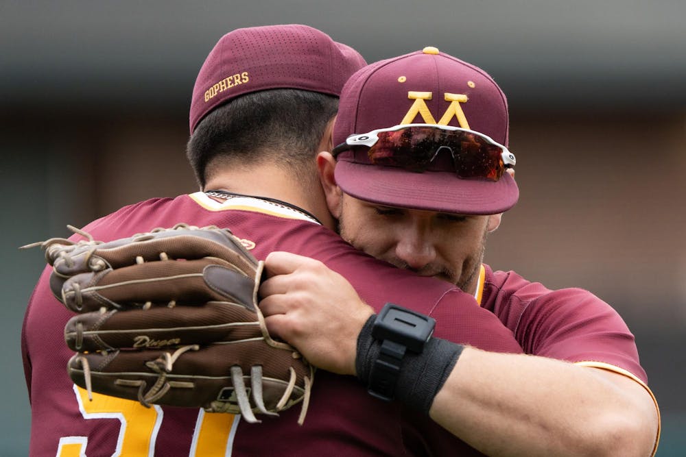 <p>Two Minnesota players hug after losing to Michigan State at McLane Stadium on May 17, 2025. The Spartans won 11-10 to close the series.</p>