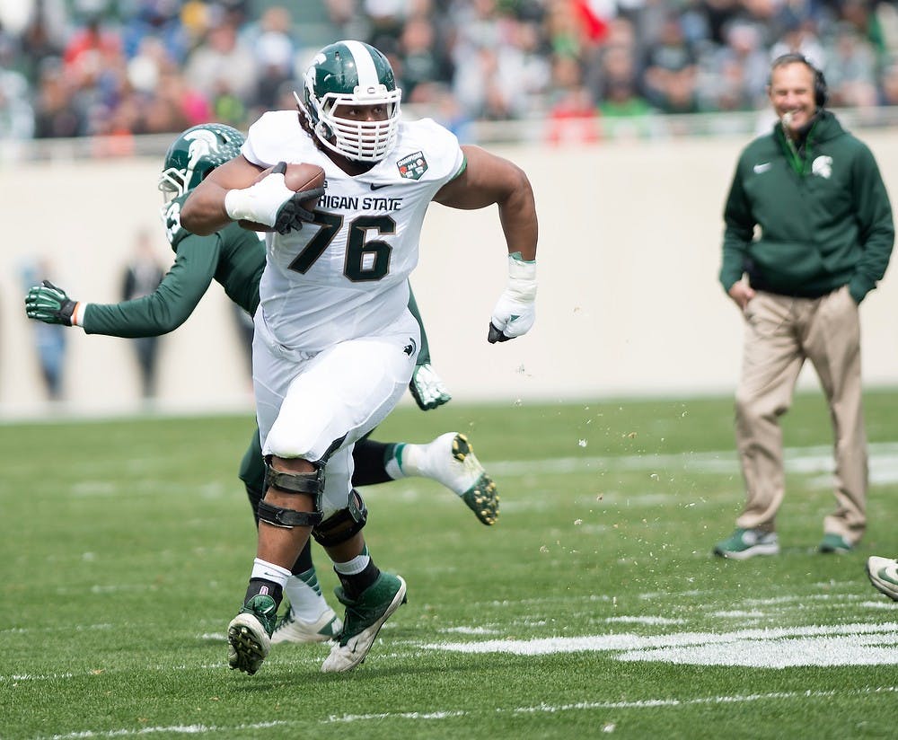 <p>Senior offensive lineman Donavon Clark, 76, runs the ball down the field April 25, 2015, during the Green and White Spring Game at Spartan Stadium. The white team defeated the green team, 9-3. Erin Hampton/The State News</p>