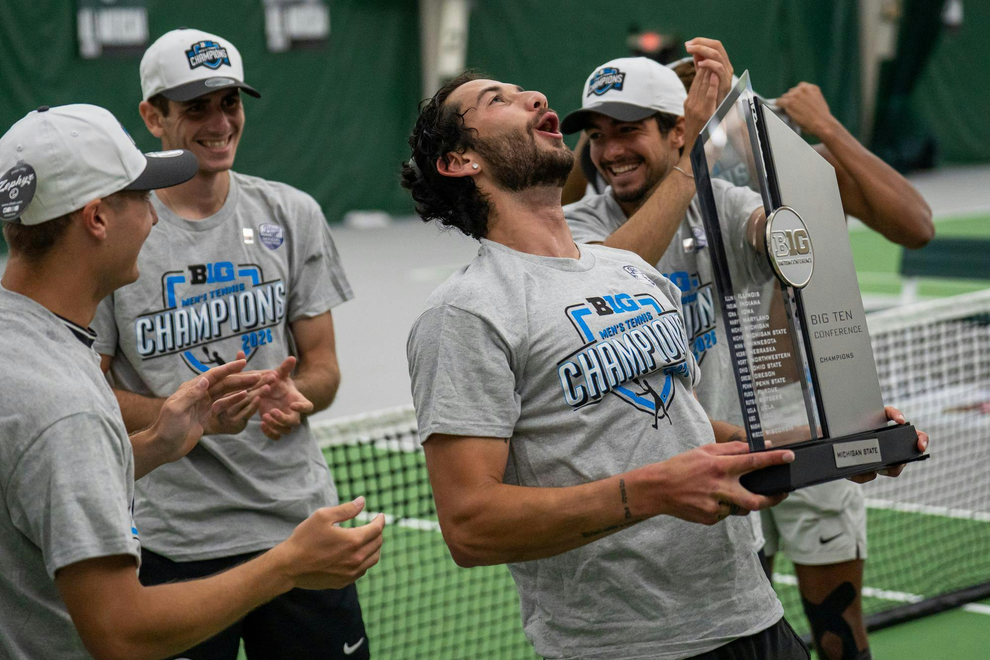 <p>Michigan State senior Ozan Baris celebrates with the Big Ten Men's Tennis Title Trophy alongside teammates at the MSU Tennis Center in East Lansing, Michigan on Sunday, April 19, 2026.</p>