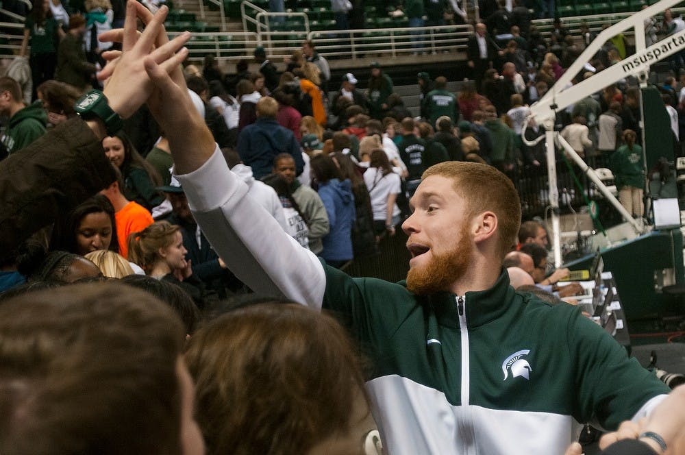 	<p>Junior guard Russell Byrd high-fives fans following the game against Columbia on Nov. 15, 2013, at Breslin Center. The Spartans defeated Columbia, 62-53, after trailing at the half. Danyelle Morrow/The State News</p>