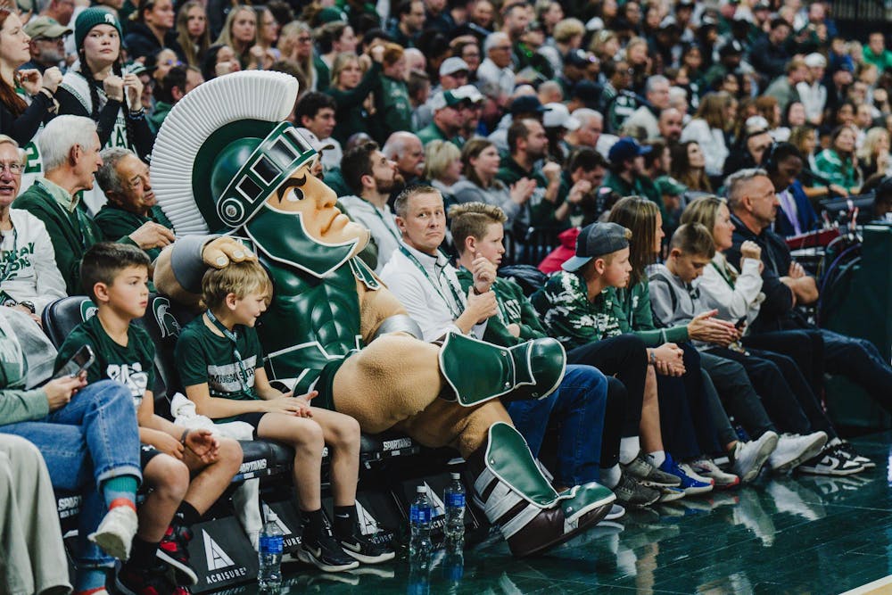 <p>A young MSU fan watches with Sparty as MSU takes on Bowling Green at the Breslin Center on Nov. 16, 2024</p>