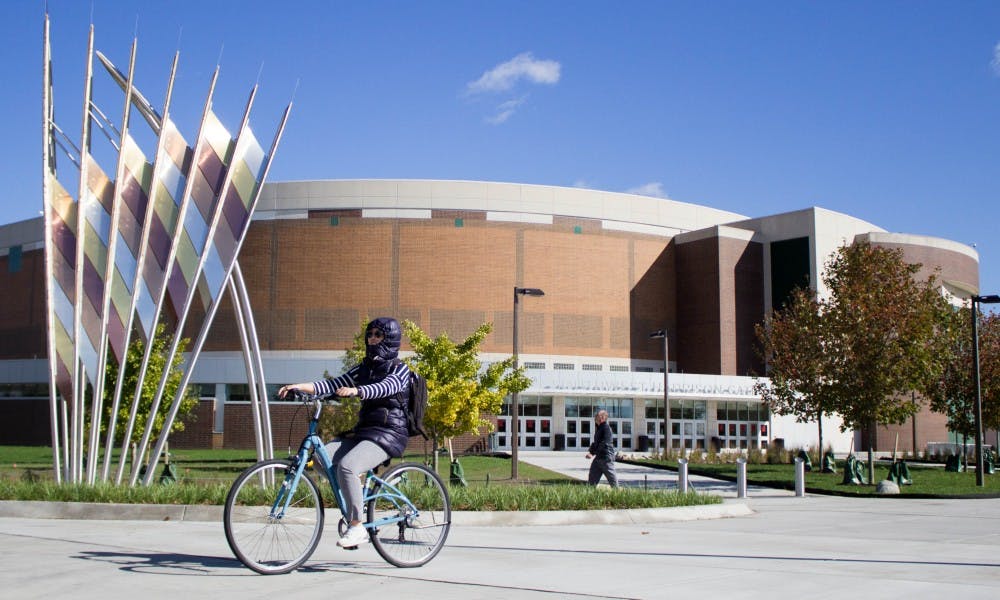 A student bikes past Breslin Center on Oct. 16, 2017. Breslin Center was recently renovated.