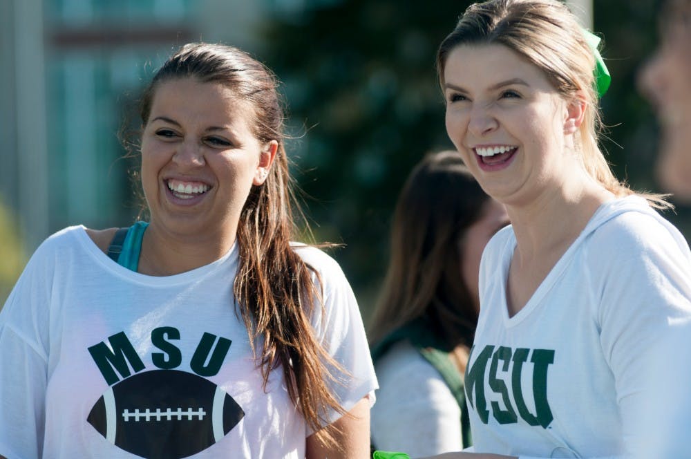 <p>Hospitality business senior Amanda Michelsen, left, and accounting senior Audrey Garneau warm up for the Amazing Spartan Race on Oct. 10, 2015, at Munn Field. Spartans Rebuilding Michigan put on the race to raise money for the Wounded Warrior Project, a charity that works to help soldiers of the Iraq and Afghanistan wars and their families with rehabilitation. </p>