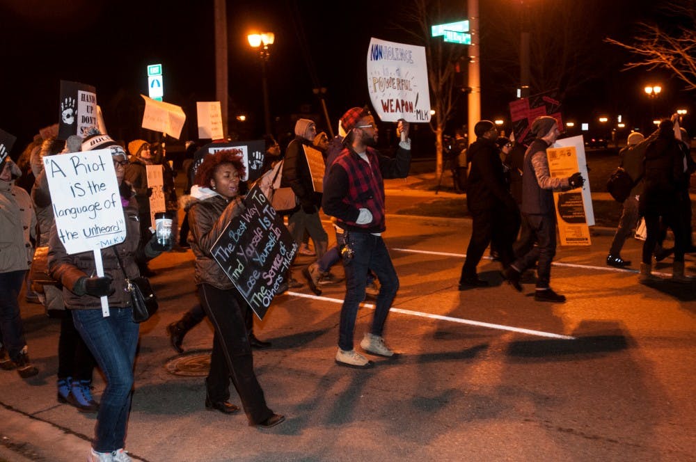 <p>Protesters hold signs as they marched on Dec. 1, 2014 to the State Capitol Building. Protesters marched and rallied to show their support for Michael Brown. Aerika Williams/The State News </p>