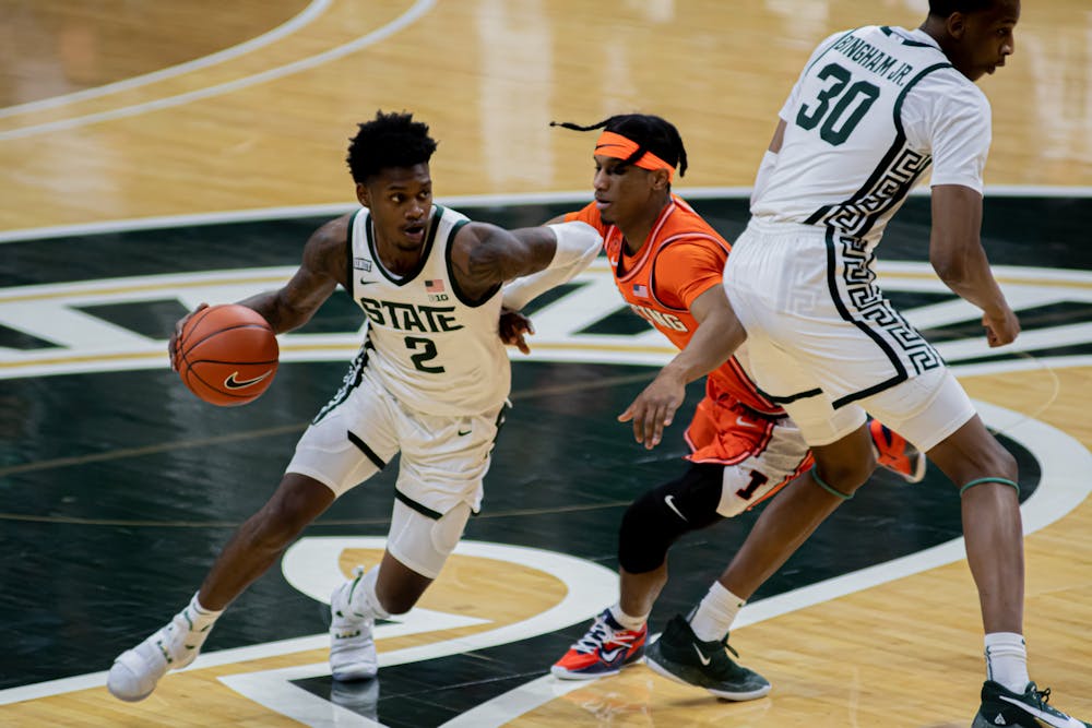 <p>Sophomore guard Rocket Watts (2) moves past senior guard Trent Frazier as junior forward Marcus Bingham Jr. (30) sets a screen. Watts&#x27; 13 points helped the Spartans edge the Fighting Illini, 81-72, on Feb. 23, 2021.</p>