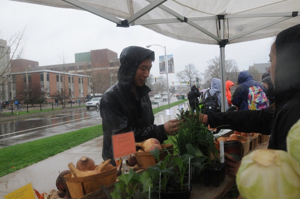 Media and information sophomore Jason Wu purchases vegetables on April 21, 2016 at the organic farm in front of MSU Auditorium. 