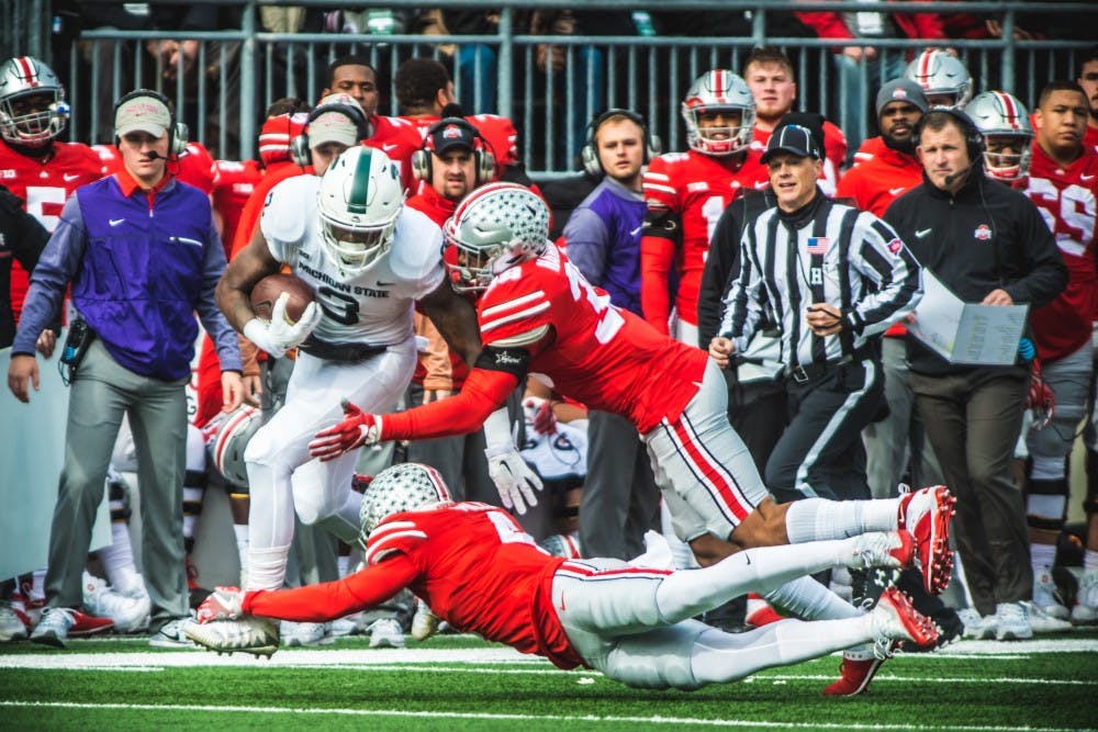 Sophomore running back L.J Scott (3) attempts to break a tackle during the game against Ohio State, on Nov. 11, 2017, at Ohio Stadium. The Spartans were defeated by the Buckeys, 48-3.