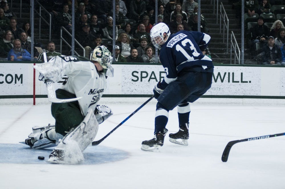 Senior goaltender Ed Minney makes a save during a break away opportunity for sophomore center Nikita Pavlychev (13) during the game on Feb. 17, 2018 at Munn Ice Arena. The Spartans trailed the Nittany Lions 3-1 after the second period. (C.J. Weiss | The State News)