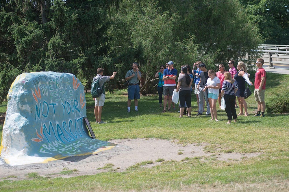 <p>A tour guide explains the Rock to a group of incoming students and their parents August 7, 2015. They explained how some messages can sometimes be political or social critiques. Catherine Ferland/ The State News </p>