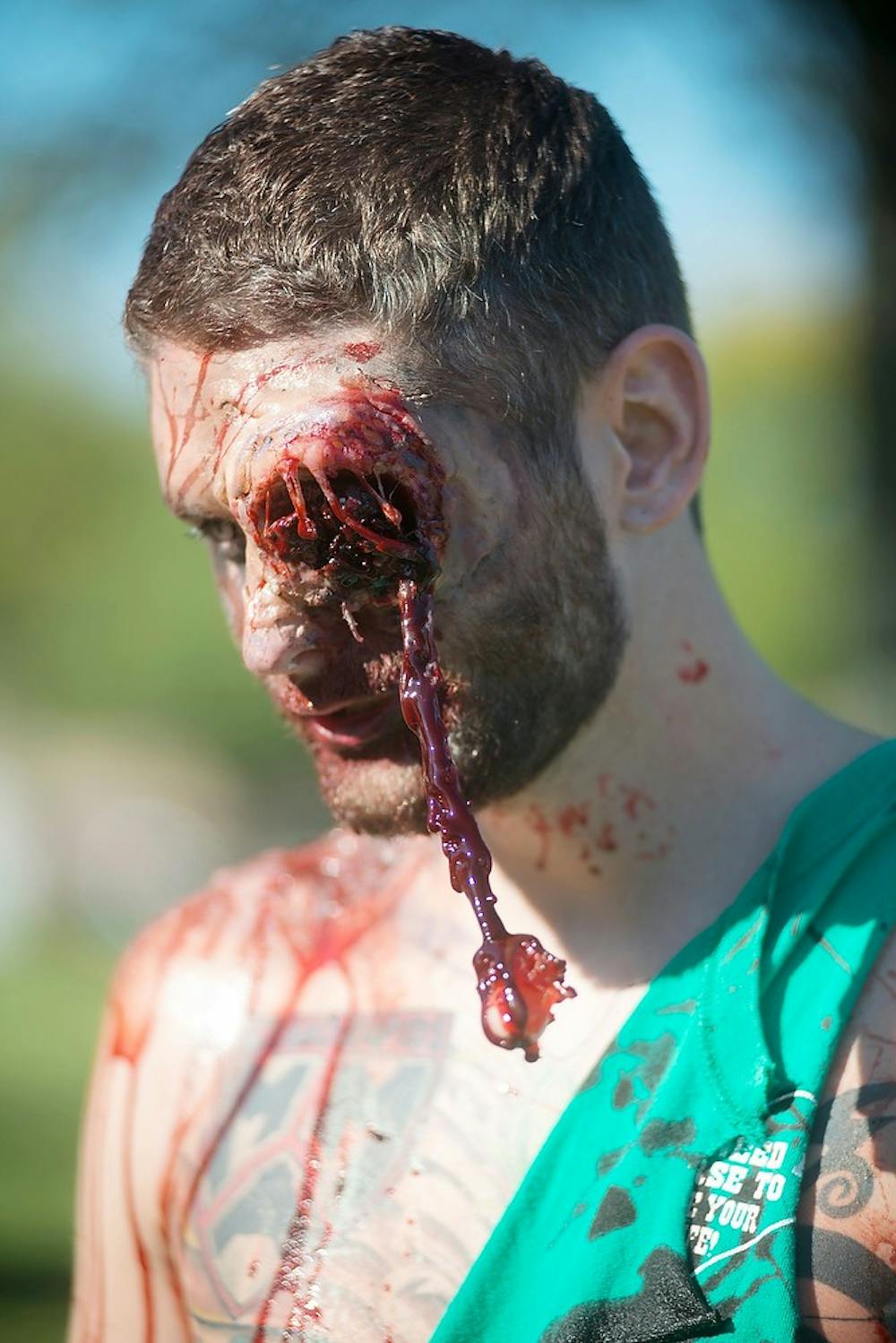 	<p>Lansing resident Travis McElhaney looks on during the annual Downtown Lansing Zombie Walk on Sept. 28, 2013, at Adado Riverfront Park. McElhaney&#8217;s roommate did his costume makeup. Julia Nagy/The State News</p>