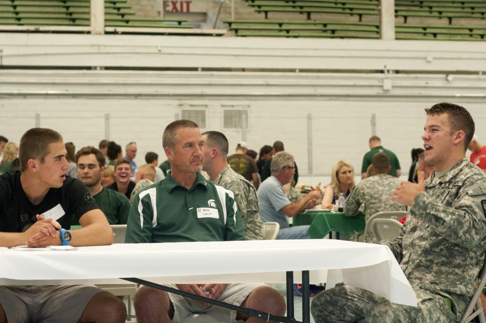 <p>Business freshman Bradley Grost, left, and Mark Grost, center, listen to advertising senior Cadet Forrest Stone speak about ROTC on Aug. 29, 2015, inside Demonstration Hall. "ROTC is time consuming," Stone said. "It's definitely tough, but you're also learning how to be a leader and that really transitions from ROTC into your schoolwork and other clubs and activities." Joshua Abraham/The State News</p>