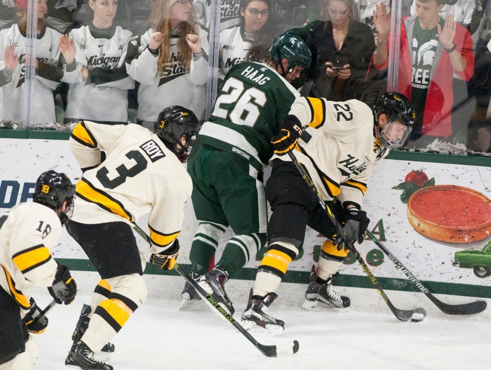 Junior forward Villiam Haag, 26, struggles to maintain control of the puck against Michigan Tech defenseman Shane Hanna, 22, during the game against Michigan Tech on Nov. 22, 2015 at Munn Ice Arena. The spartans tied with the Huskies, 4-4.