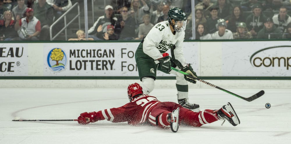 <p>Senior forward Jagger Joshua (23) reaches for the puck during a game of ice hockey between MSU and Wisconsin at Munn Ice Arena on Nov. 4, 2022. The Spartans won, 5-0.</p>