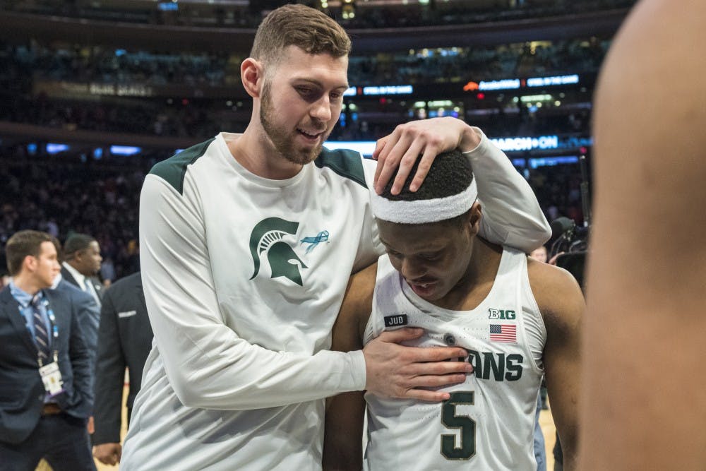 Graduate student forward Ben Carter (13) embraces sophomore guard Cassius Winston (5) after MSU won 2018 Big Ten Men's Basketball quarterfinal game against Wisconsin on March 2, 2018 at Madison Square Garden in New York. (Nic Antaya | The State News)