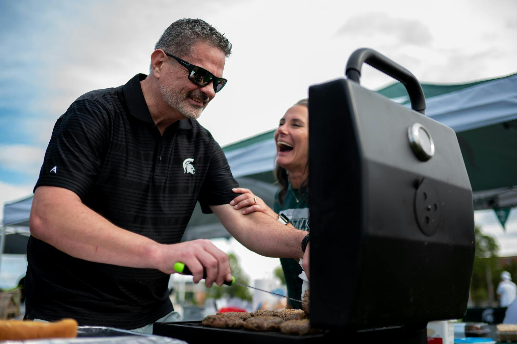 <p>Scott Larkins, 50, of Clarkston, grilling while at a tailgate at Michigan State University's Munn Intramural Field ahead of the first game of the 2025 season against Western Michigan University in East Lansing, Michigan on Aug. 29, 2025.</p>