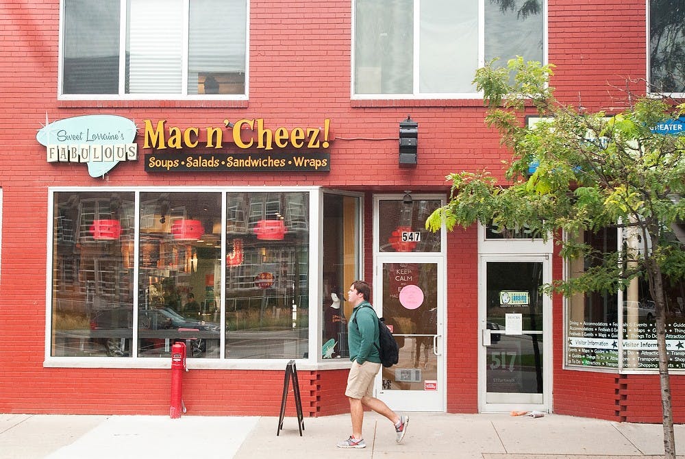 <p>A pedestrian walks past Sweet Lorraine's Fabulous Mac N' Cheez restaurant on Sept. 15, 2014. Raymond Williams/The State News</p>