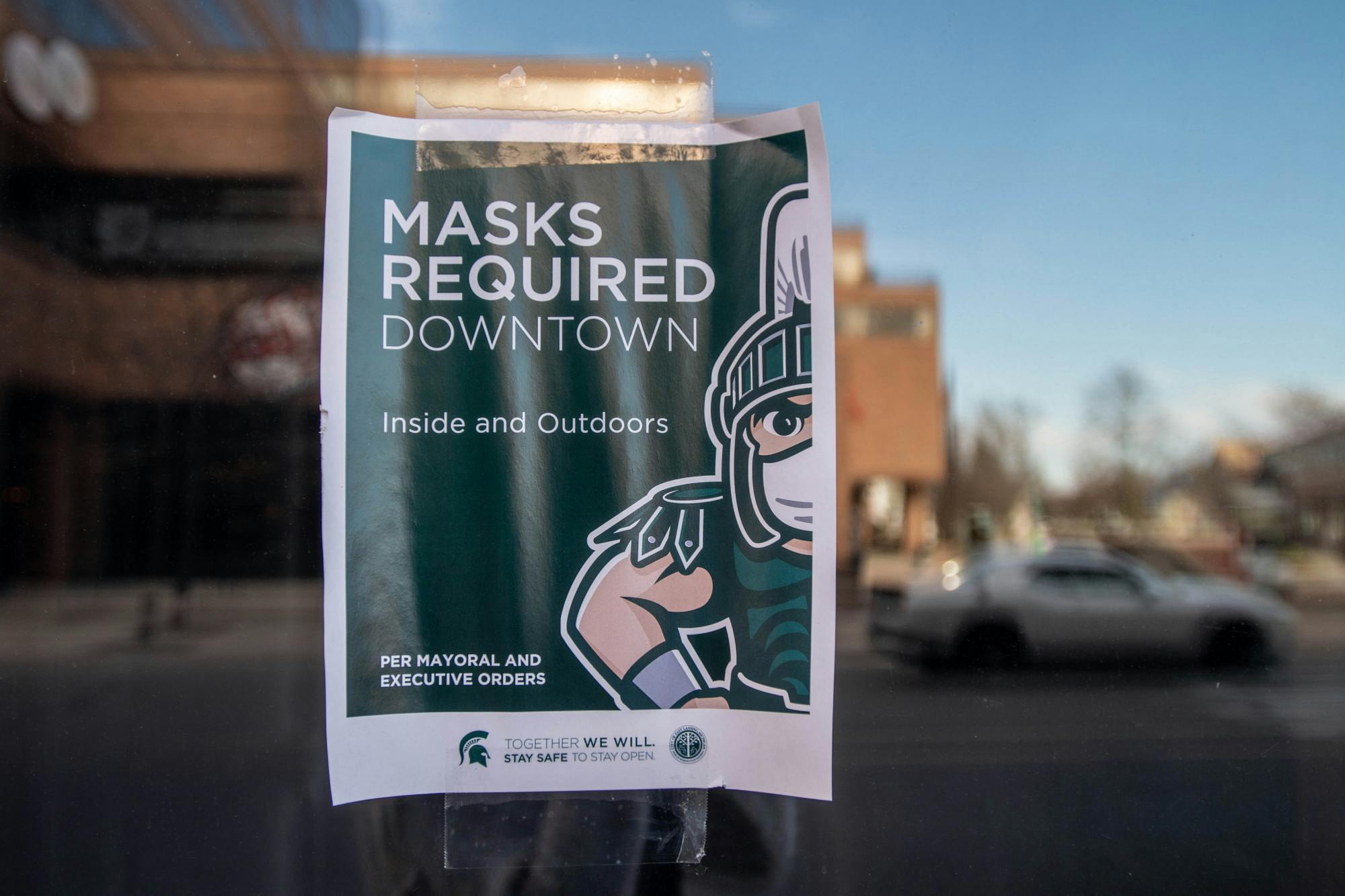 A sign posted on a window in downtown East Lansing on Nov. 20, 2020.