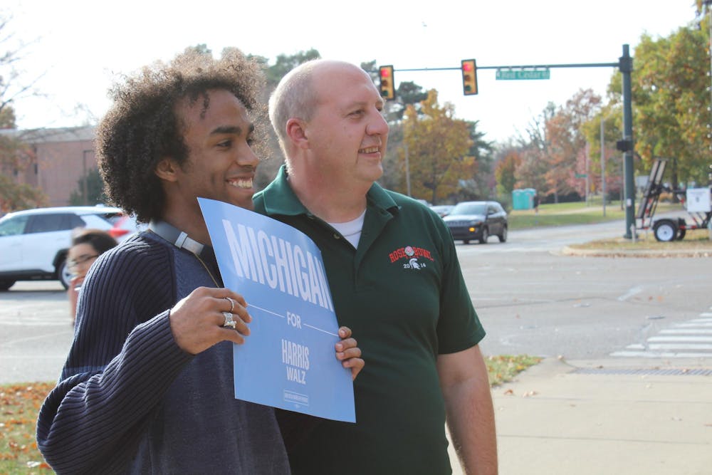 Candidate for the U.S. House Michigan's District 7 seat Curtis Hertel Jr. takes a picture with a student at an early voting rally on Oct. 29, 2024. 