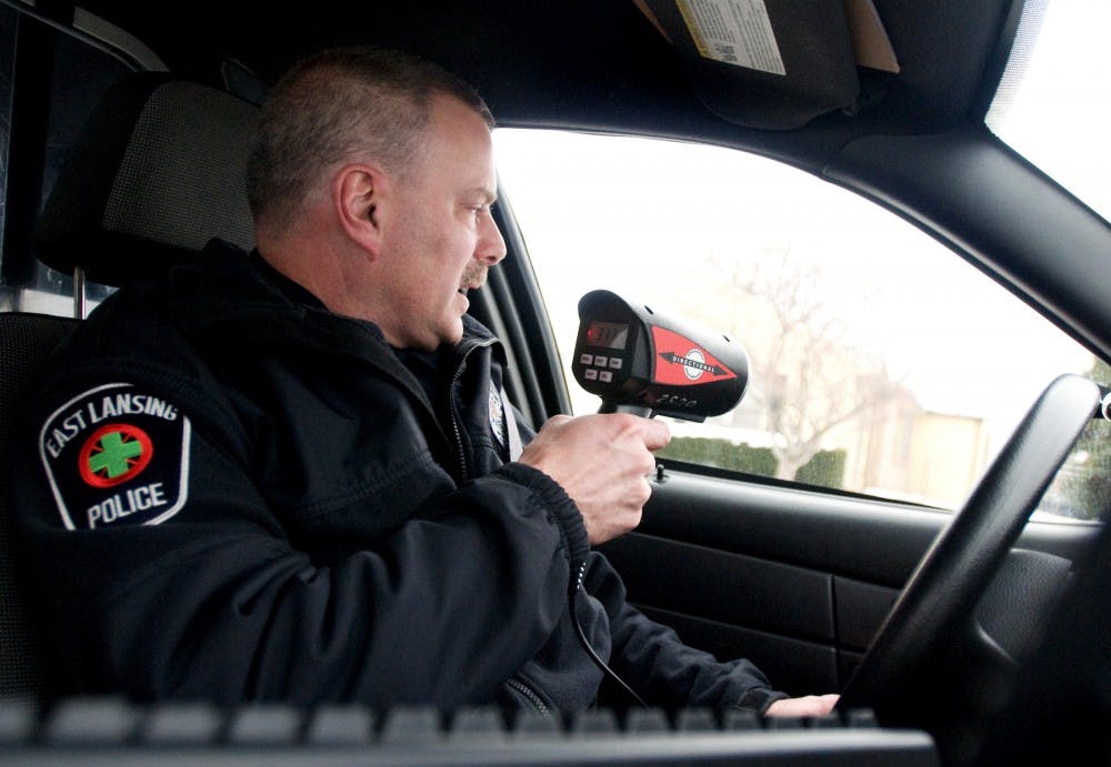East Lansing Police officer Tom Blanck uses a radar gun to monitor drivers on Haslett Road on Wednesday in East Lansing. Over the last two years the East Lansing Police Department has received more than $1 million in grant money, which will largely be used on new equipment. Kat Petersen/The State News