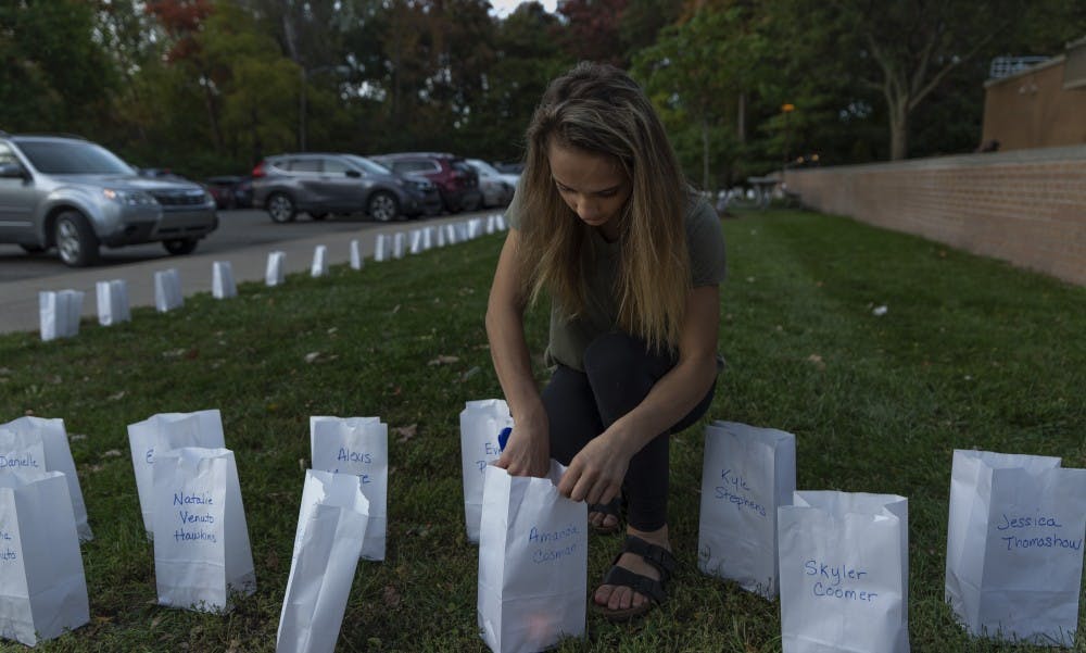 Amanda Cosman, 14, lights a candle in her own luminary on Oct. 10, 2019 at the East Lansing Public Library. POSSE lit 505 luminaries signifying the known survivors Larry Nassar at the East Lansing Public Library, before President Stanley’s meeting with survivors. 