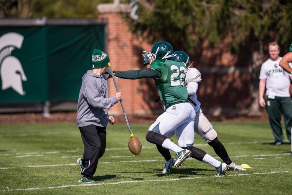 Senior running back Delton Williams breaks past sophomore linebacker Byron Bullough during a drill on April 5, 2016 at the practice fields behind the Duffy Daugherty Football Building.