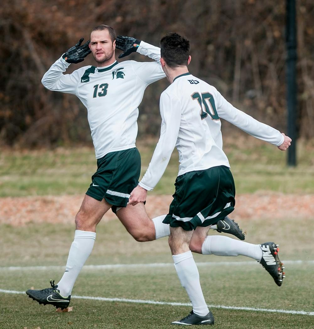 <p>Senior forward Adam Montague celebrates with junior midfielder Jay Chapman after his first goal in the game  against Providence College on Dec. 6, 2014, at DeMartin Stadium at Old College Field. The Spartans were defeated by the Friars, 2-3. Raymond Williams/The State News</p>