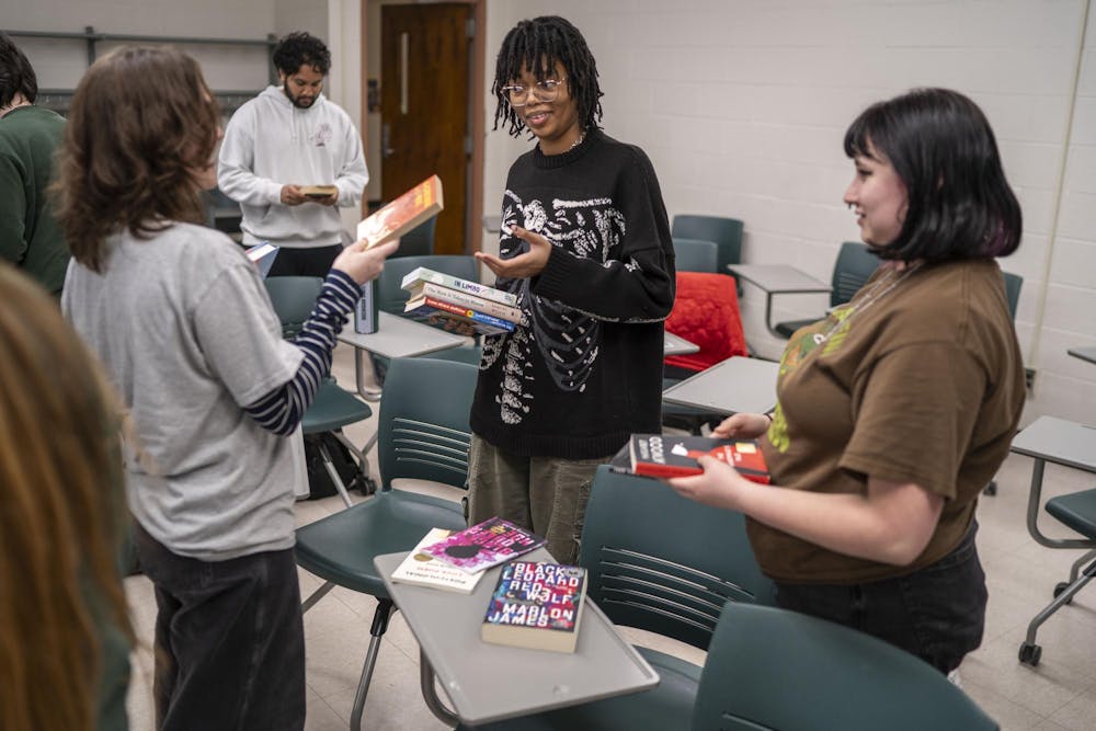 Students swap books during Sigma Tau Delta's Banned Book Night at Wells Hall on April 21, 2025.