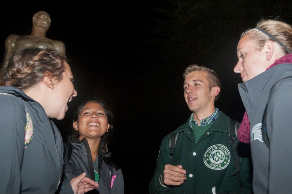 <p>From left to right, advertising junior Julianne Frontiero, business law sophomore Katherine Fernandez, chemical engineering sophomore Lucas Layher, and spanish junior Alison Trainor chat on Tuesday next to Sparty. Frontiero said that she loves that no matter the weather, the marching band guards the statue during rivalry week. </p>