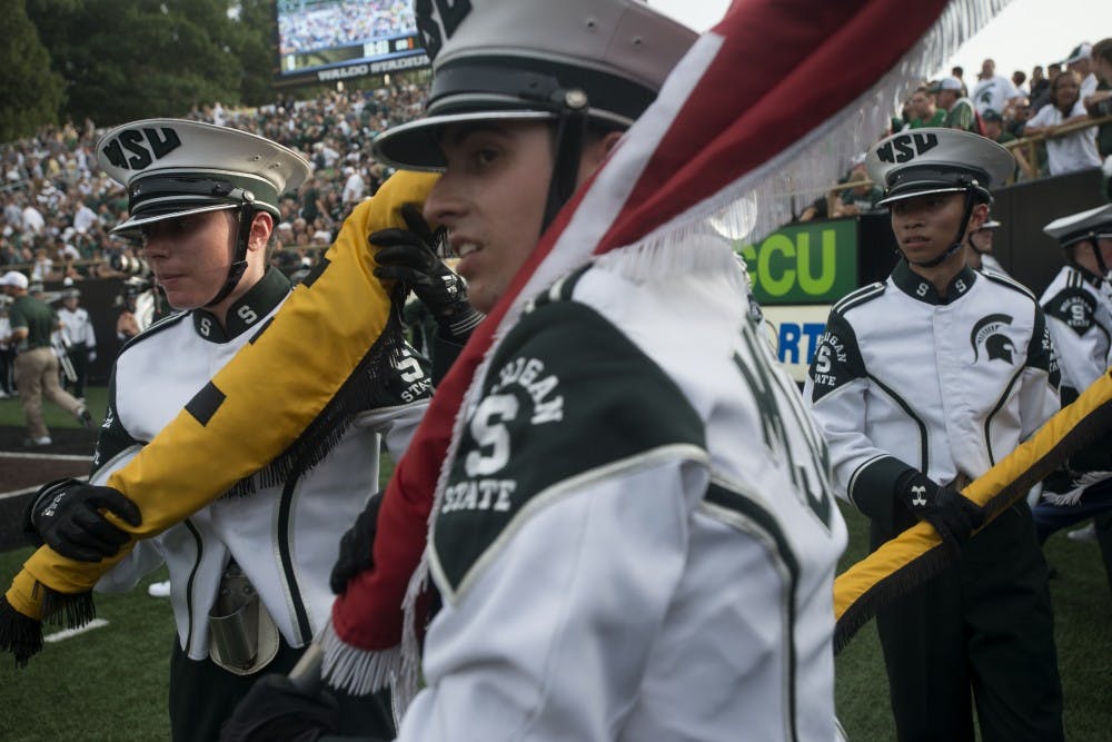 <p>From left to right, biomedical laboratory science senior Rebecca Brosig, political science senior Nick Reynolds and neuroscience sophomore Jason Nguyen wait to run out onto the field with the rest of the Spartan Marching Band on Sept. 4, 2015, before a game against Western Michigan at Waldo Stadium in Kalamazoo, Mich. The Spartans beat the Broncos, 37-24. Julia Nagy/The State News</p>