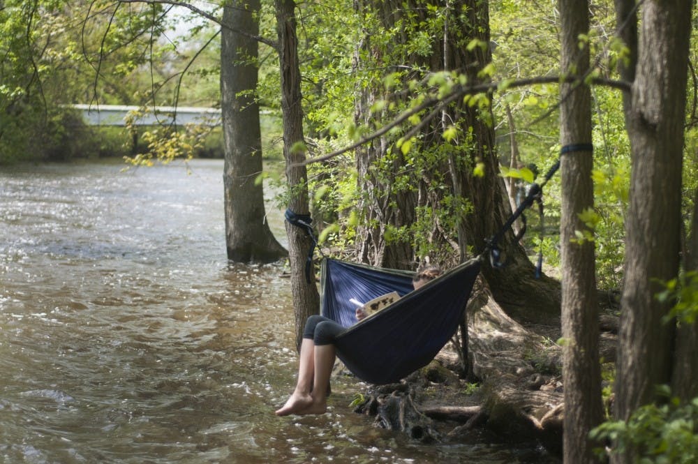 Zoology junior Ayla Skelton studies for her physics class on May 16, 2016 along the Red Cedar River. Skelton said she likes to study outside.