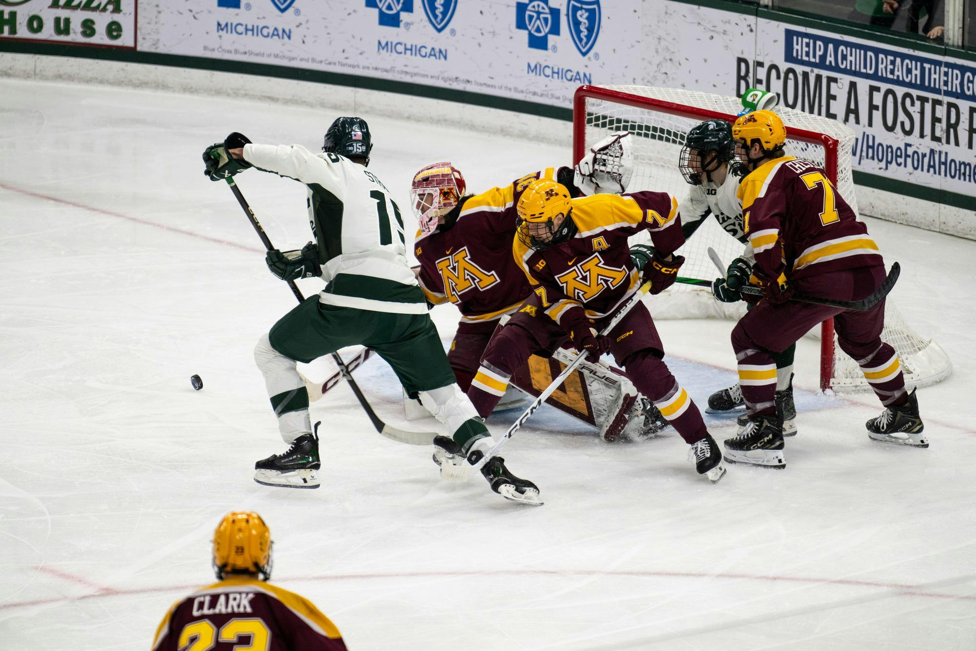 Michigan State junior forward Charlie Stramel (15) chases a rebound at Munn Ice Arena on Jan. 25, 2025. The Spartans completed a regular season sweep of the Golden Gophers following a 4-3 shootout victory.