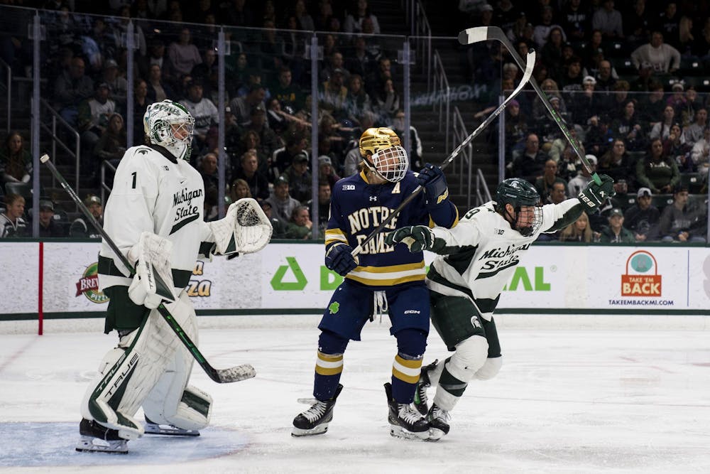 <p>Michigan State University junior defenseman Matt Basgall (9) blocks a Notre Dame player from getting the puck at Munn Ice Arena on Nov. 16, 2024. MSU defeated Notre Dame 4-3.</p>