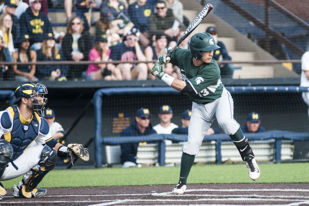 <p>Sophomore infielder Royce Ando (13) looks to hit the ball during the game against University of Michigan on April 18, 2017 at Ray Fisher Stadium in Ann Arbor. The Spartans were defeated by the Wolverines, 12-4.</p>