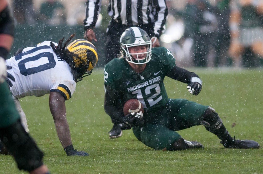 Redshirt freshman quarterback Rocky Lombardi (12) carries the ball during the game against Michigan at Spartan Stadium on Oct. 20, 2018. The Spartans fell to the Wolverines 7-21.