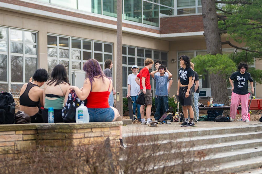 Members of MSU Skate Club laugh and converse between tricks during skate club outside of Shaw Hall on Michigan State University’s campus in East Lansing, Mich., highlighting the community within the club on March 20, 2026.