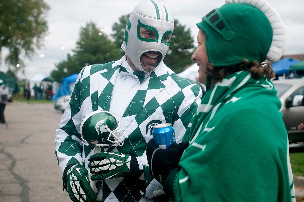 <p>Freeland, Mich., resident "Sparty Libre," left, talks to Holland, Mich., resident Beth Felicelli during tailgating before the game against Nebraska on Oct. 4, 2014, at Spartan Stadium. The Spartans defeated the Cornhuskers, 27-22. Jessalyn Tamez/The State News</p>