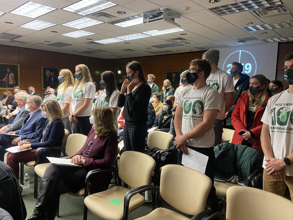 <p>Members of the Battle for MSU Swim and Dive stand in support of their fellow student speaker at the Board of Trustees meeting on Feb. 11.</p>
