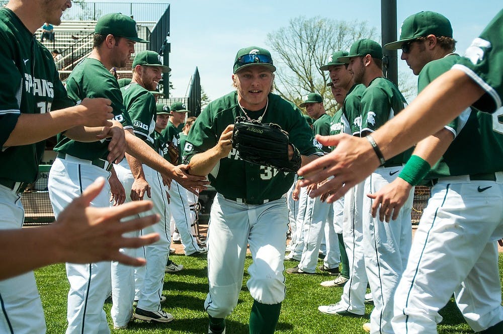 <p>Sophomore left fielder Cam Gibson high fives teammates while running onto the field before the game against Nebraska on May 11, 2014, at McLane Baseball Stadium at Old College Field. The Cornhuskers defeated the Spartans, 4-1. Danyelle Morrow/The State News</p>